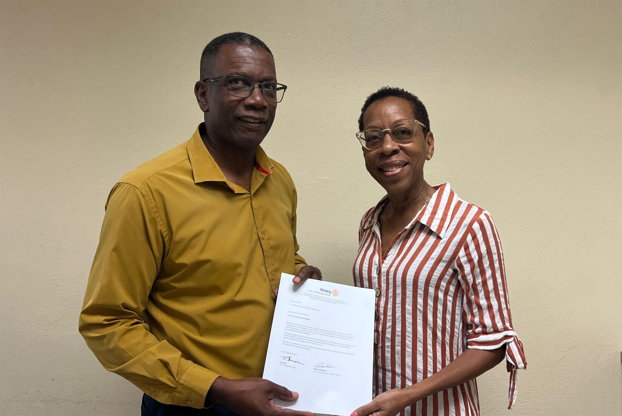 President Terry presenting the vouchers to Mr. Colin St Hill of the child care board
