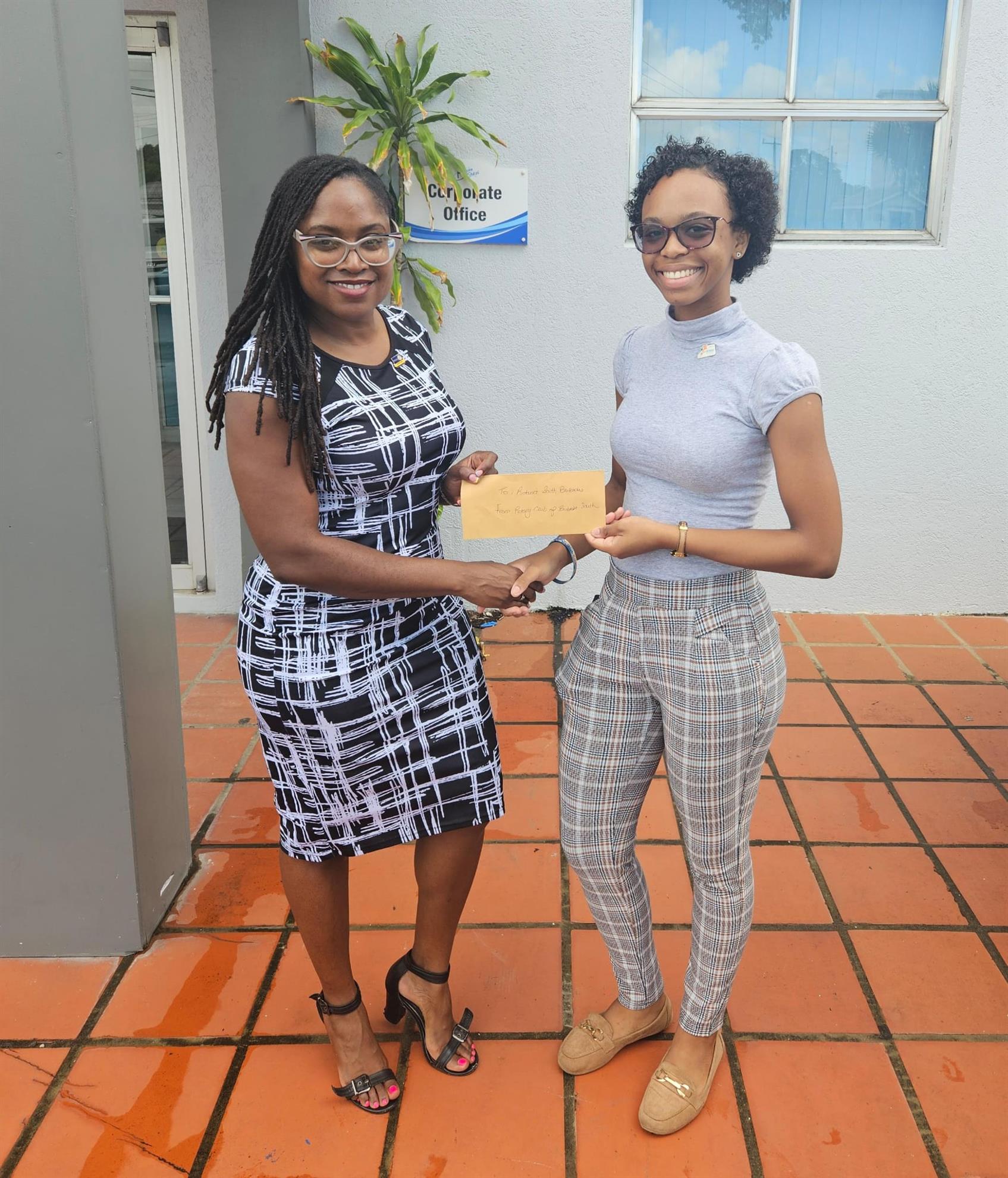 Director Kemi presenting the $550 for the reading room project to the RCSB president