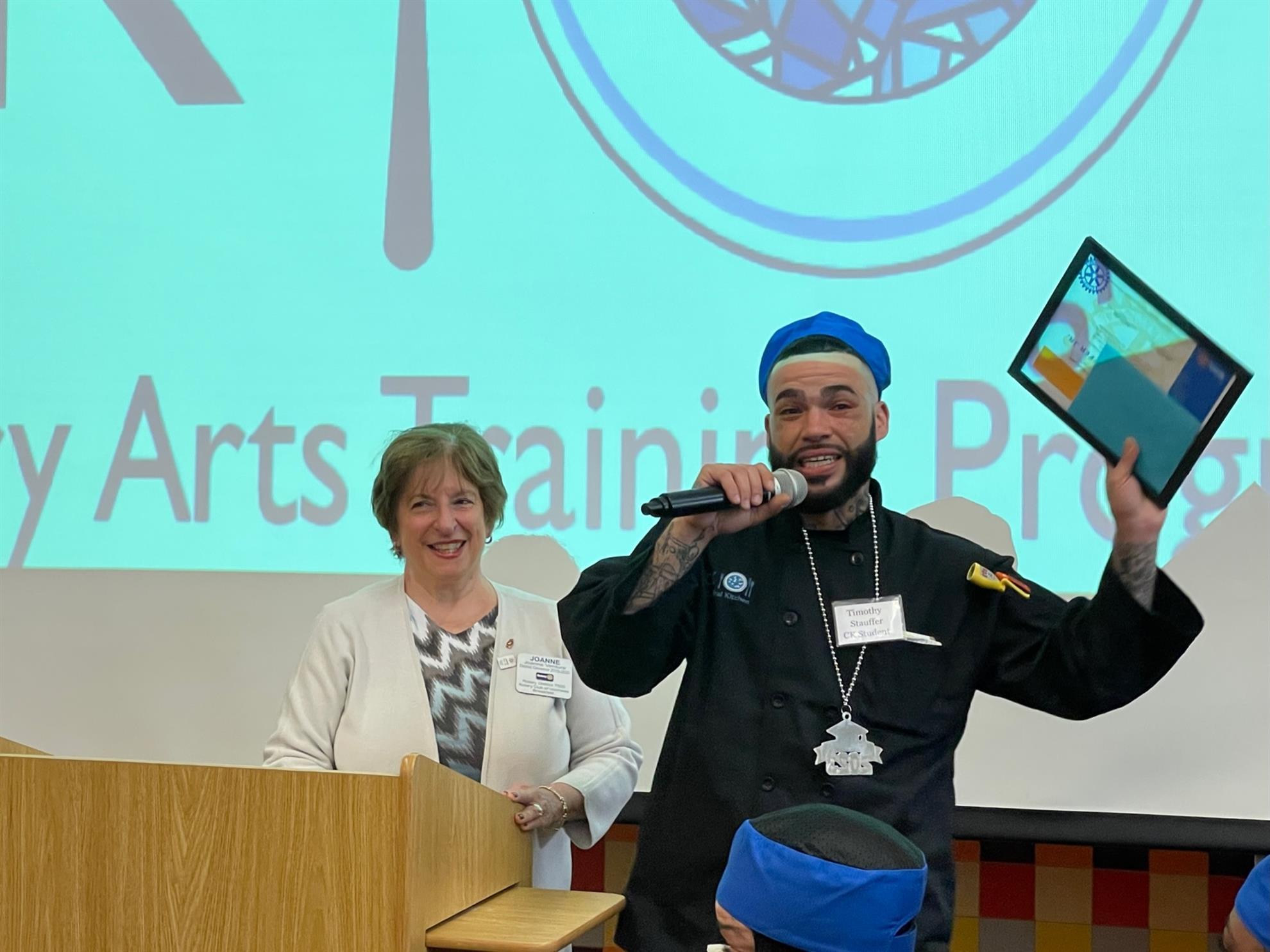 President Joanne Ventura awards a Cathedral Kitchen Culinary Arts Grad, 4-20-23