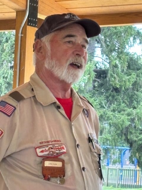 Boy Scouts and adults at a picnic lunch