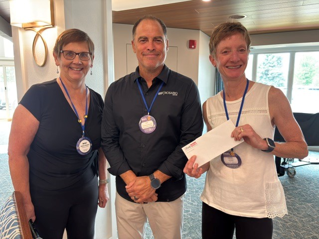 Cris Rosario presenting check to Becky Hammer and Leslie Olson