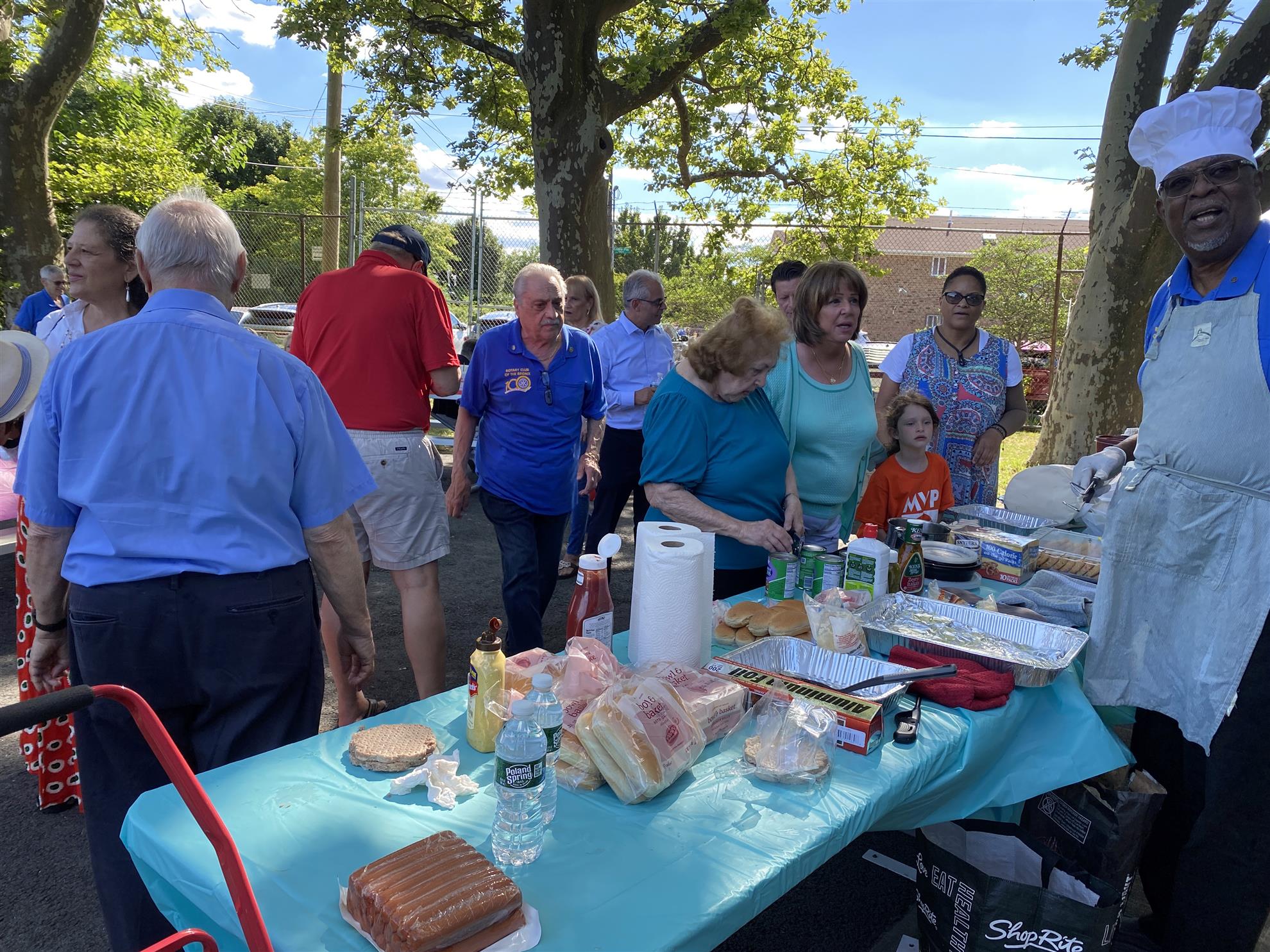 Rotarians and guests enjoying a wide variety of picnic treats with grill master Eugene Oliver grilling to order.