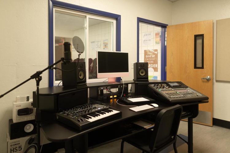 Recording studio with speakers, keyboard, and sound dashboard.