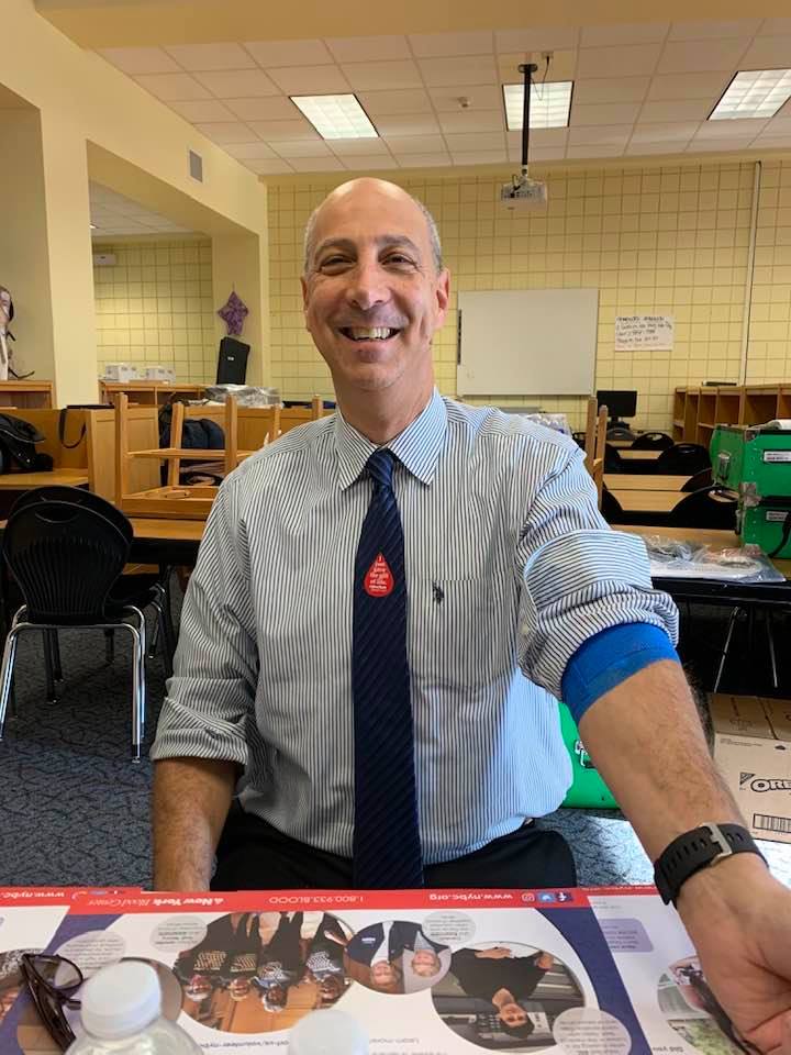 Rotarian Bruce Anapol smiling while donating blood.