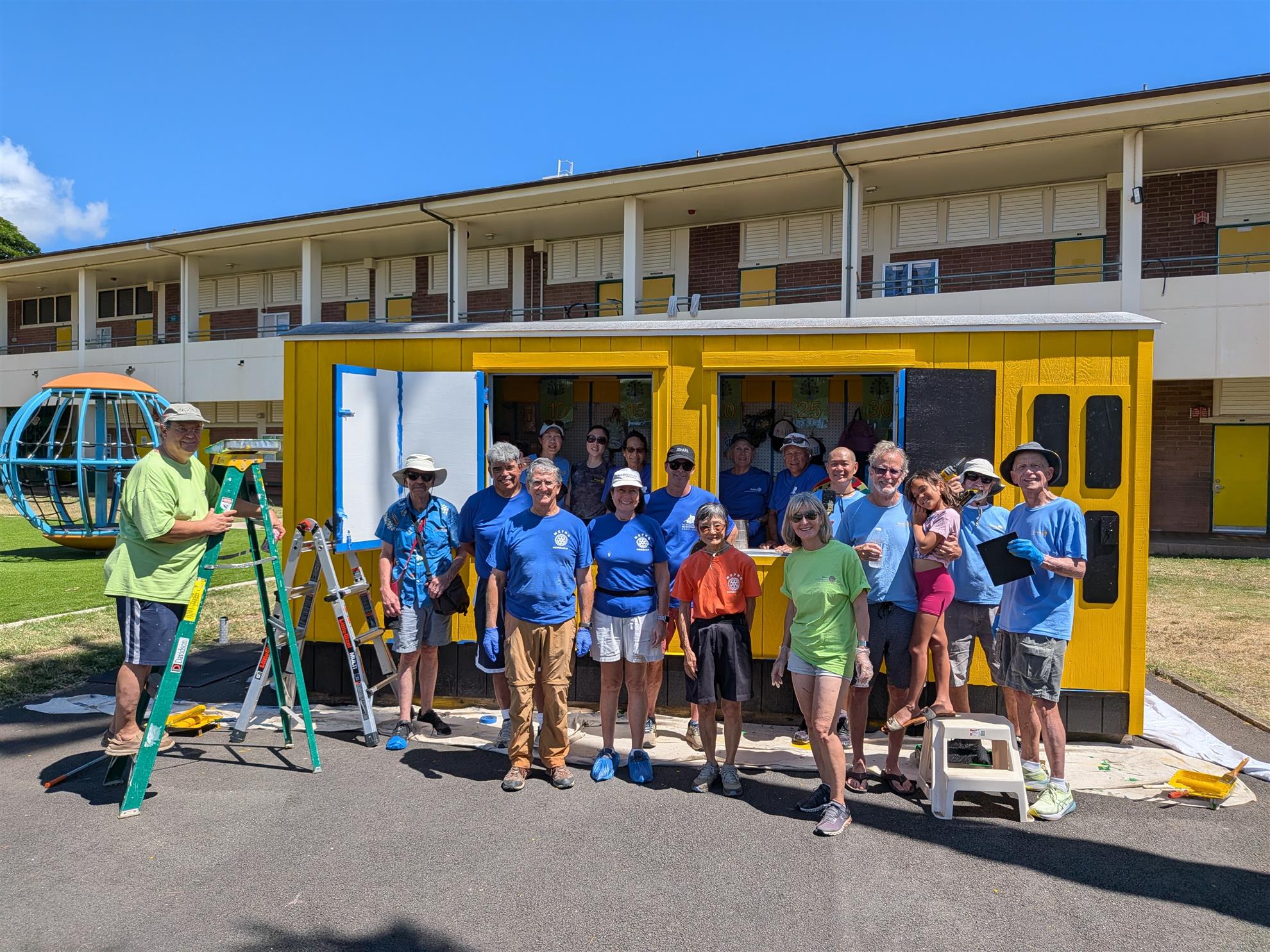The volunteer team gathered in front of the freshly painted structure