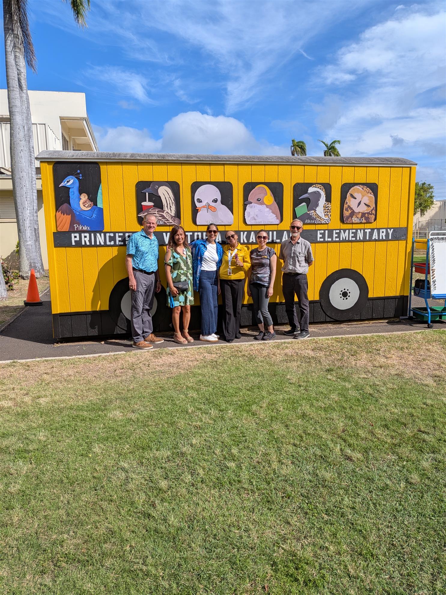 A group gathered beside the finished Peacock Bus