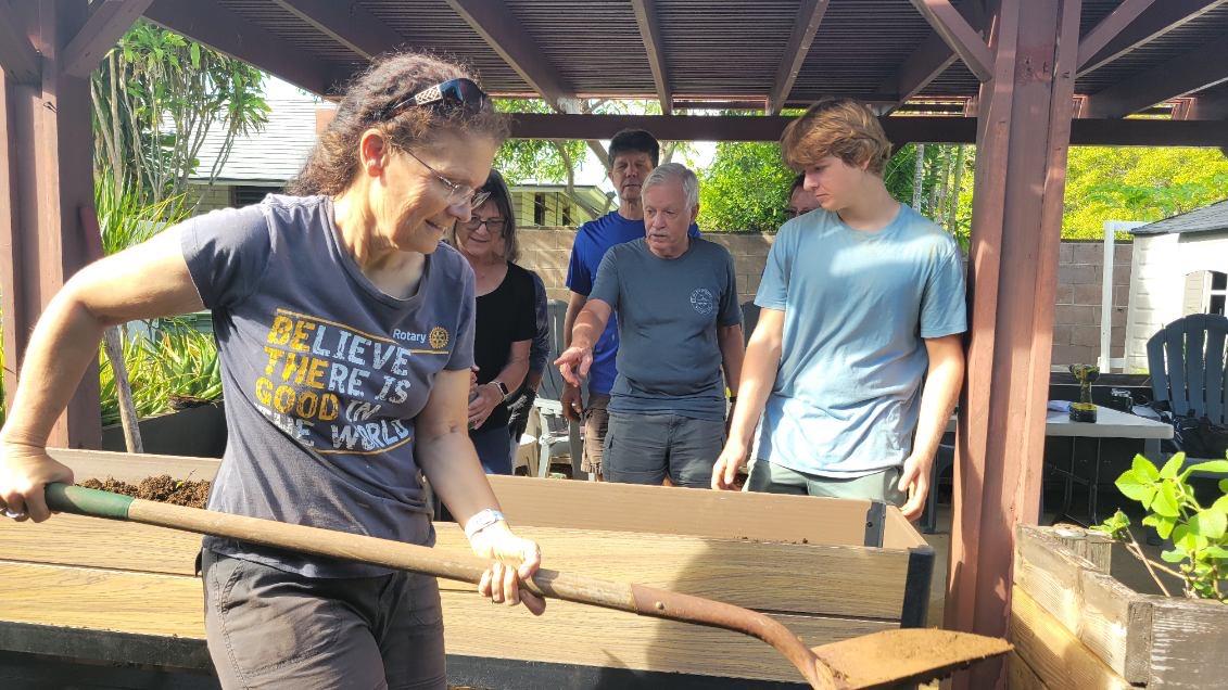 A volunteer shoveling soil into the planter boxes