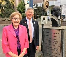 A person and person standing next to a statueAI-generated content may be incorrect.