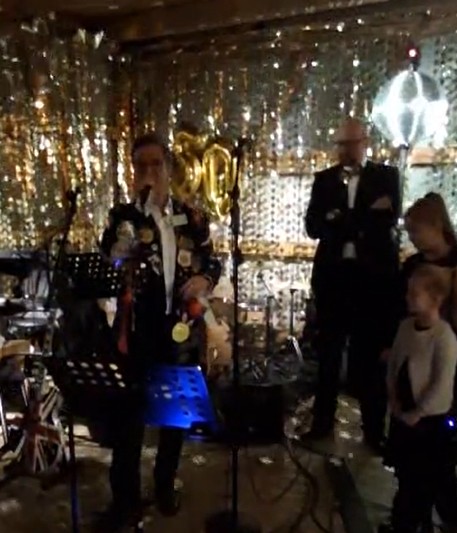 A person singing into a microphone in front of a group of peopleAI-generated content may be incorrect.