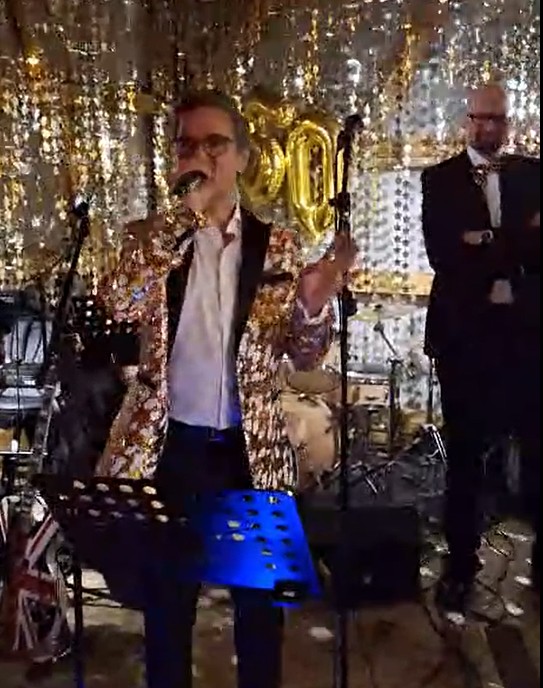 A person singing into a microphoneAI-generated content may be incorrect.