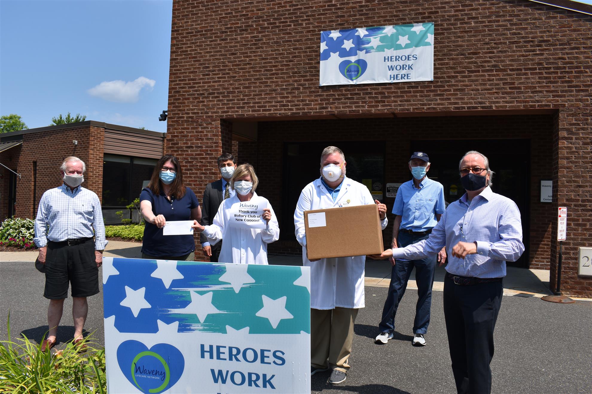 Rotary Club of New Canaan members present a check and supplies of Personl Protective Equipment to Waveny Lifecare Network in New Canaan