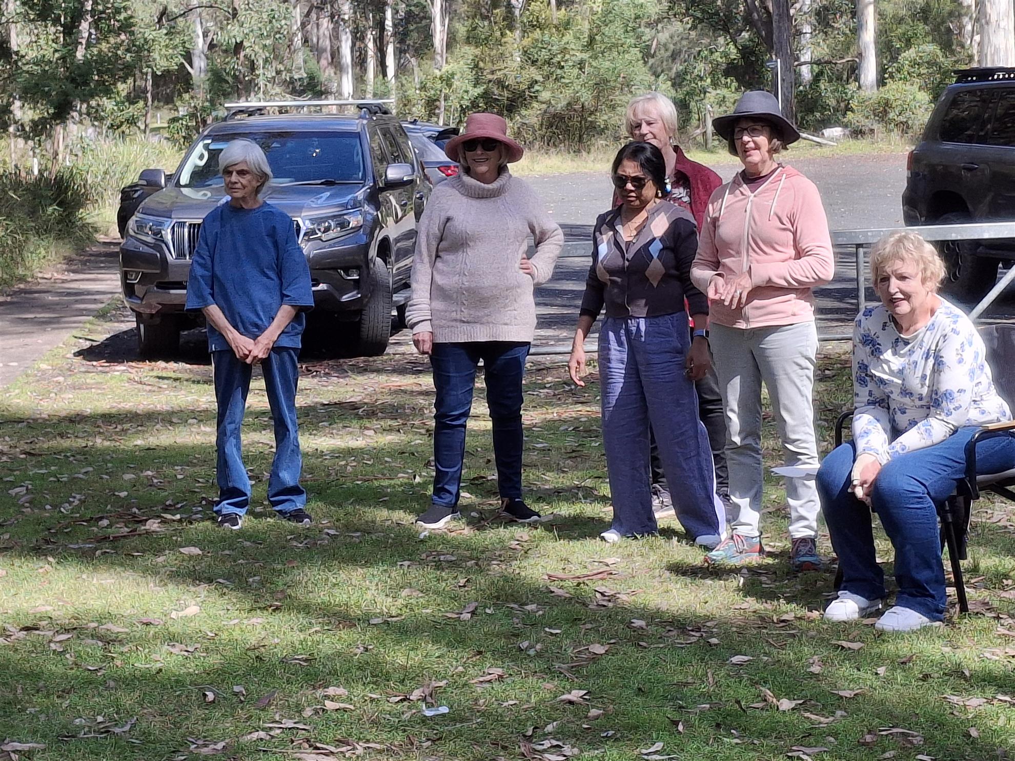 A group of attendees standing and chatting near parked cars