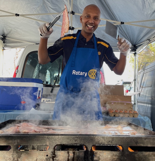 Rotarian Nathan at the barbecue cooking bacon and eggs for breakfast at Stirling Farmers Market