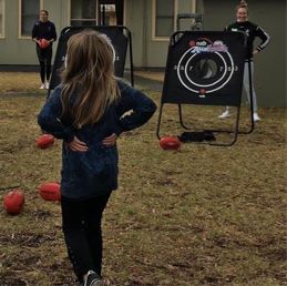 Young person practicing Aussie Rules Football with handballs into Auskick goals 