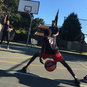 Young person playing basketball into a hoop