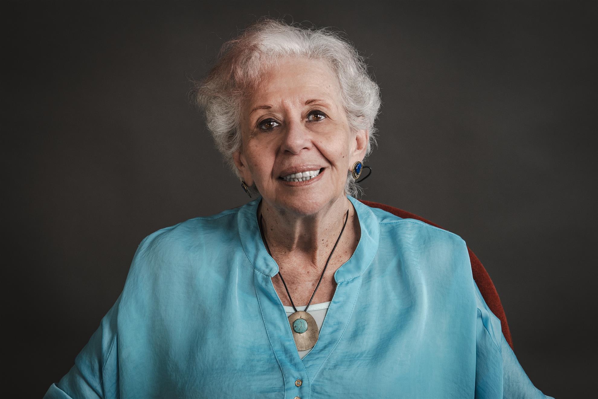 Portrait of Marta Almeida Gil smiling and wearing a turquoise blouse
