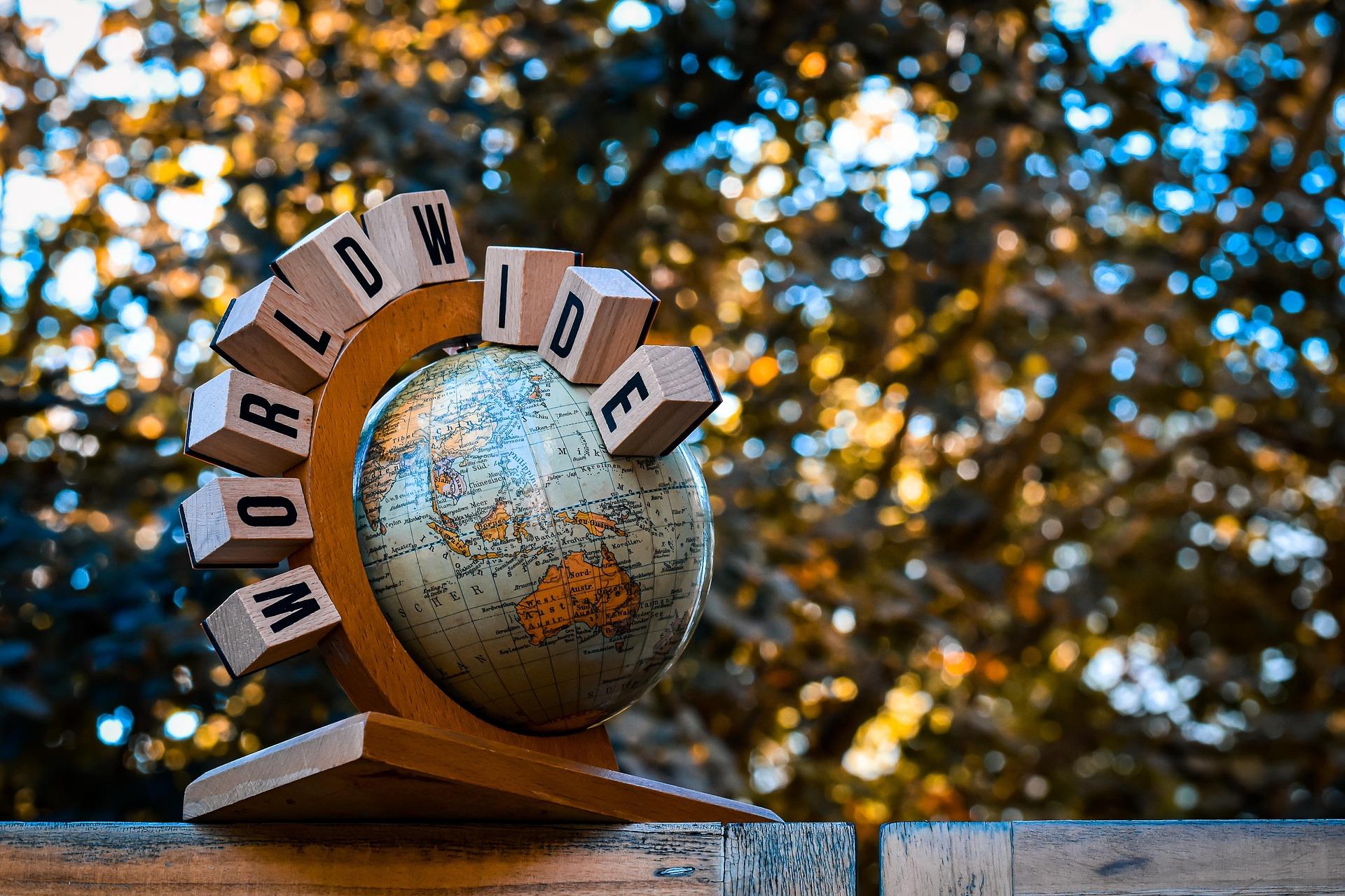 A small globe with wooden letters spelling “WORLDWIDE,” symbolizing the global effort to identify and promote accessible places through community mapping.