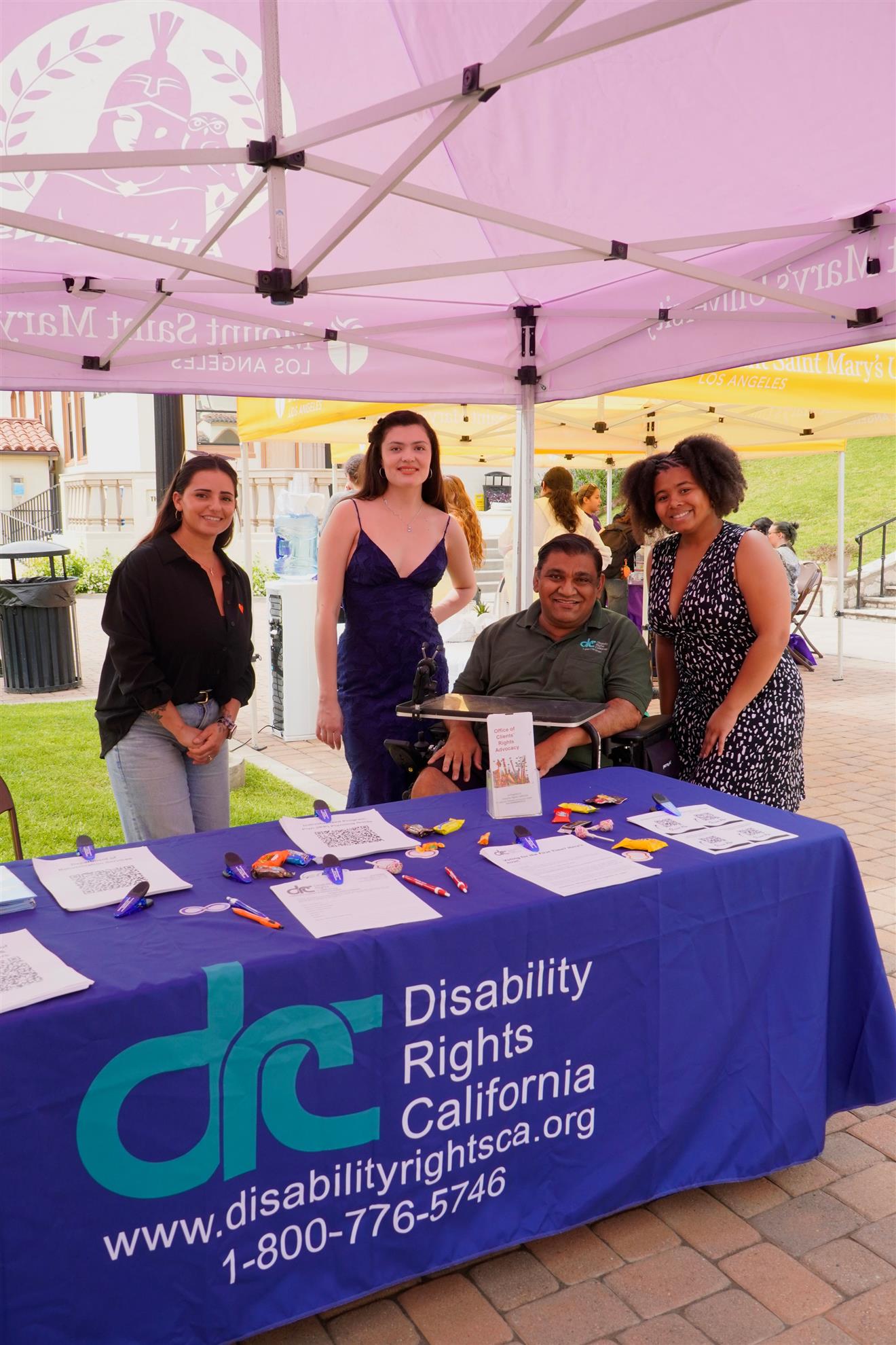 Emily Ouimette with participants at a Disability Rights California information table during a disability inclusion event