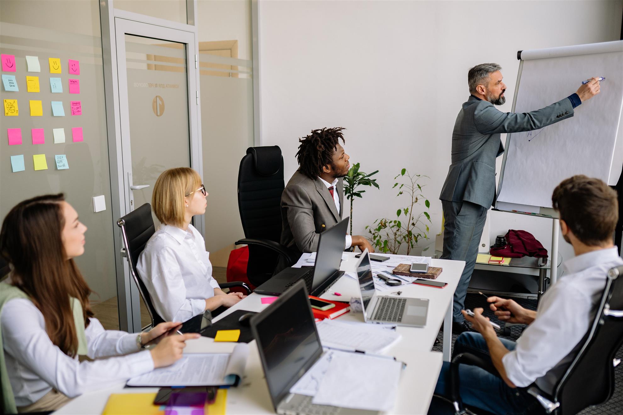 A presenter leading a workshop for colleagues in a meeting room.