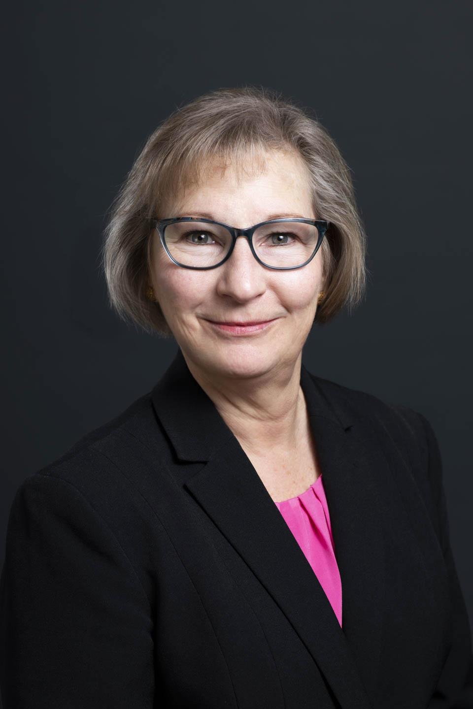 A person in a black suit and glassesAI-generated content may be incorrect.