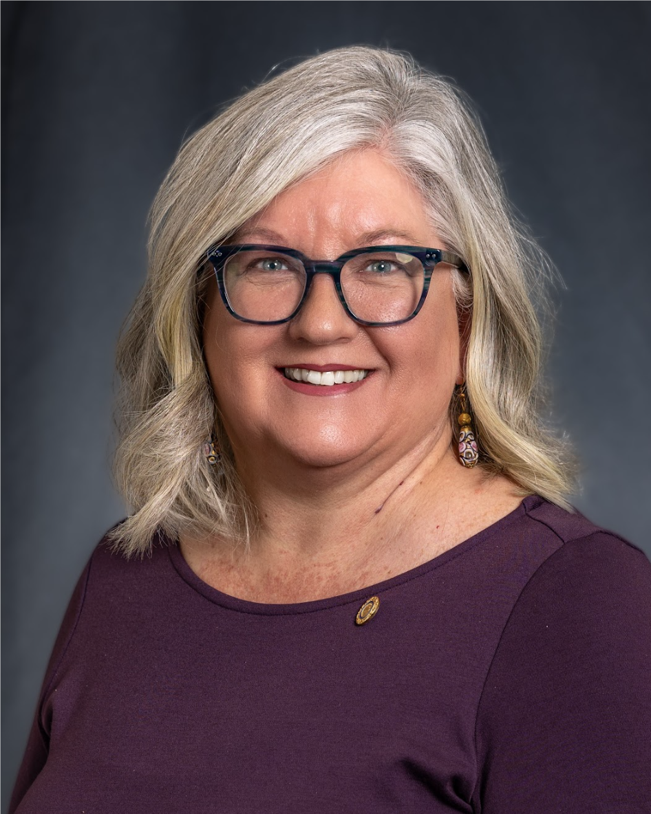 A person wearing glasses and a purple shirtAI-generated content may be incorrect.