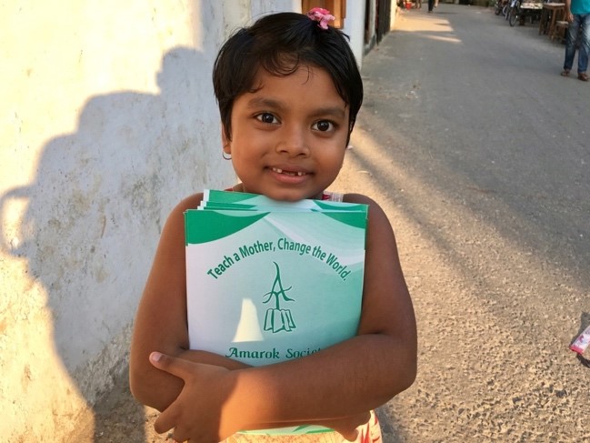 A child holding a bookDescription automatically generated with low confidence