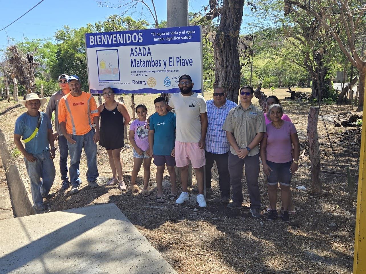 Community members in western Costa Rica standing in front of a sign recognizing their Rotary-funded water project