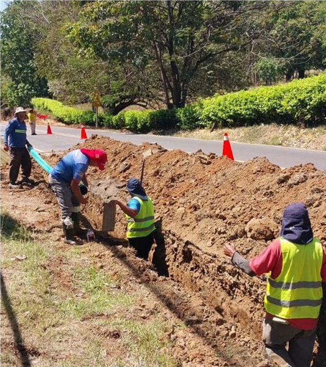 Workers trenching alongside a road to lay new water lines in Curime, Costa Rica
