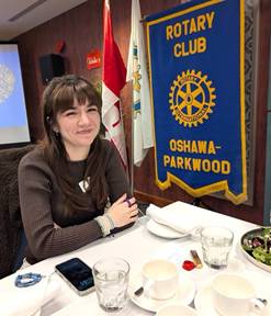 A person sitting at a table with a bannerDescription automatically generated