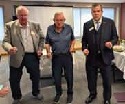 A group of men standing in a roomDescription automatically generated