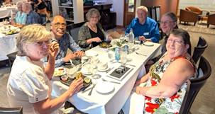 A group of people sitting around a tableDescription automatically generated