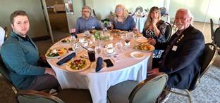 A group of people sitting at a round tableDescription automatically generated