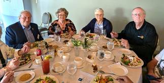 A group of people sitting around a tableDescription automatically generated