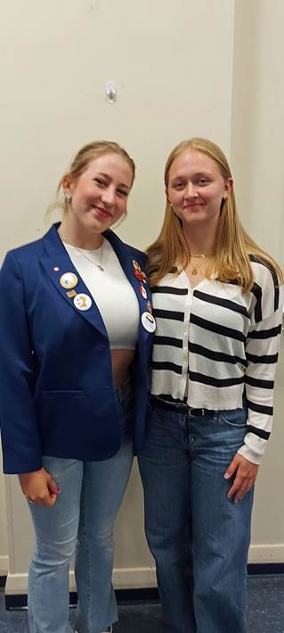 Two women standing together smilingAI-generated content may be incorrect.