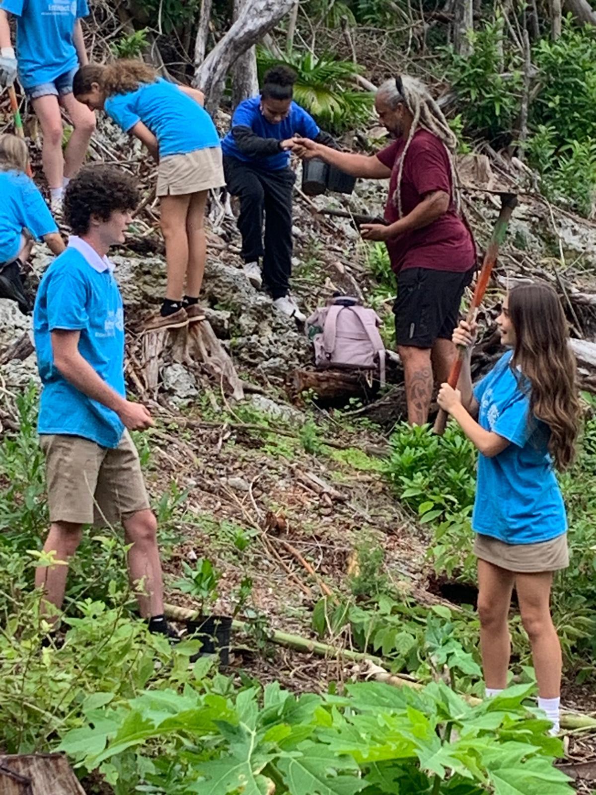 A group of people standing on a hillDescription automatically generated